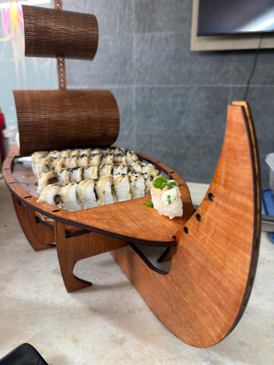Barco de madera con rolls servidos en un evento