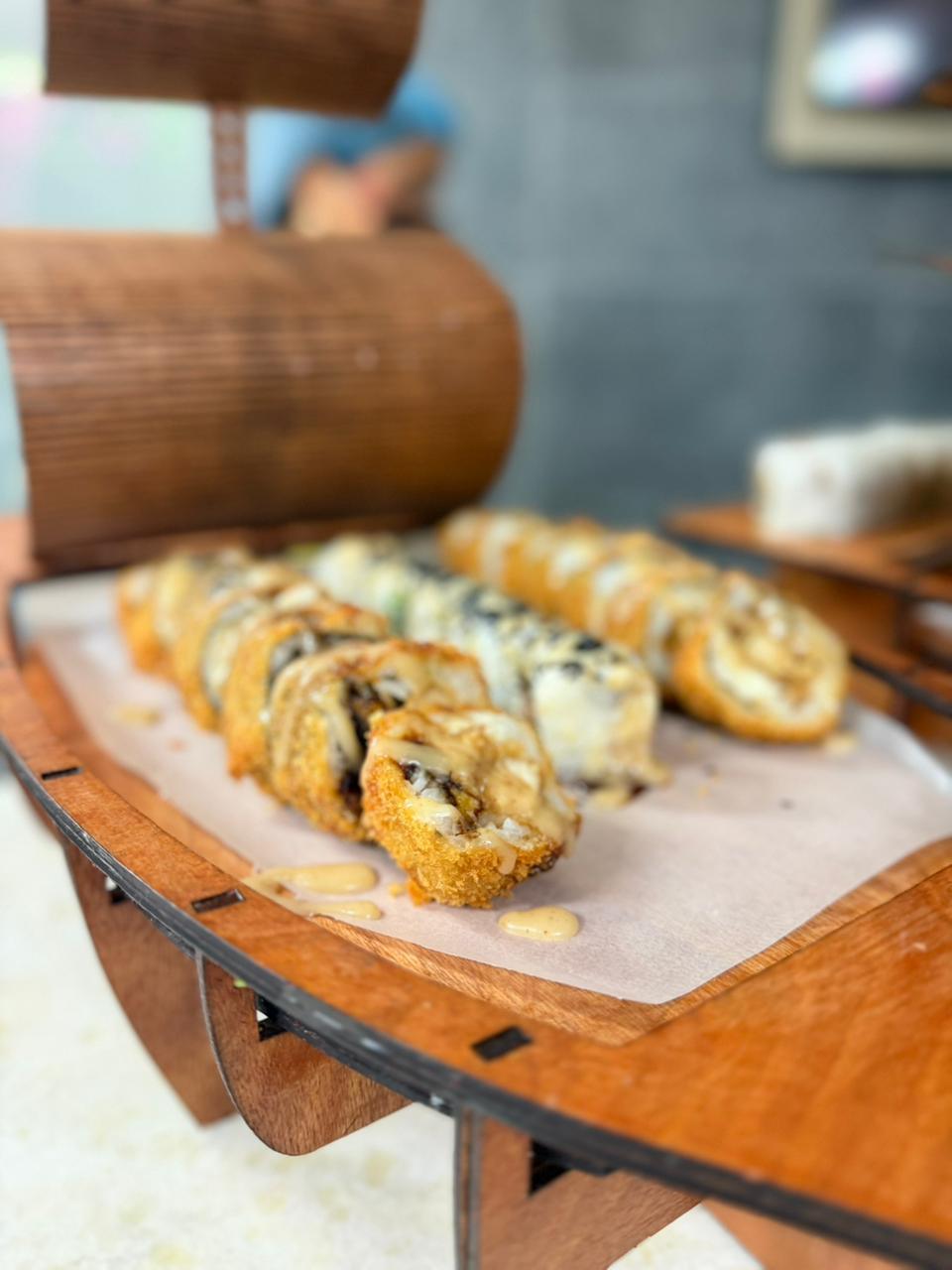 Detalle de rolls crunchy en barco de madera